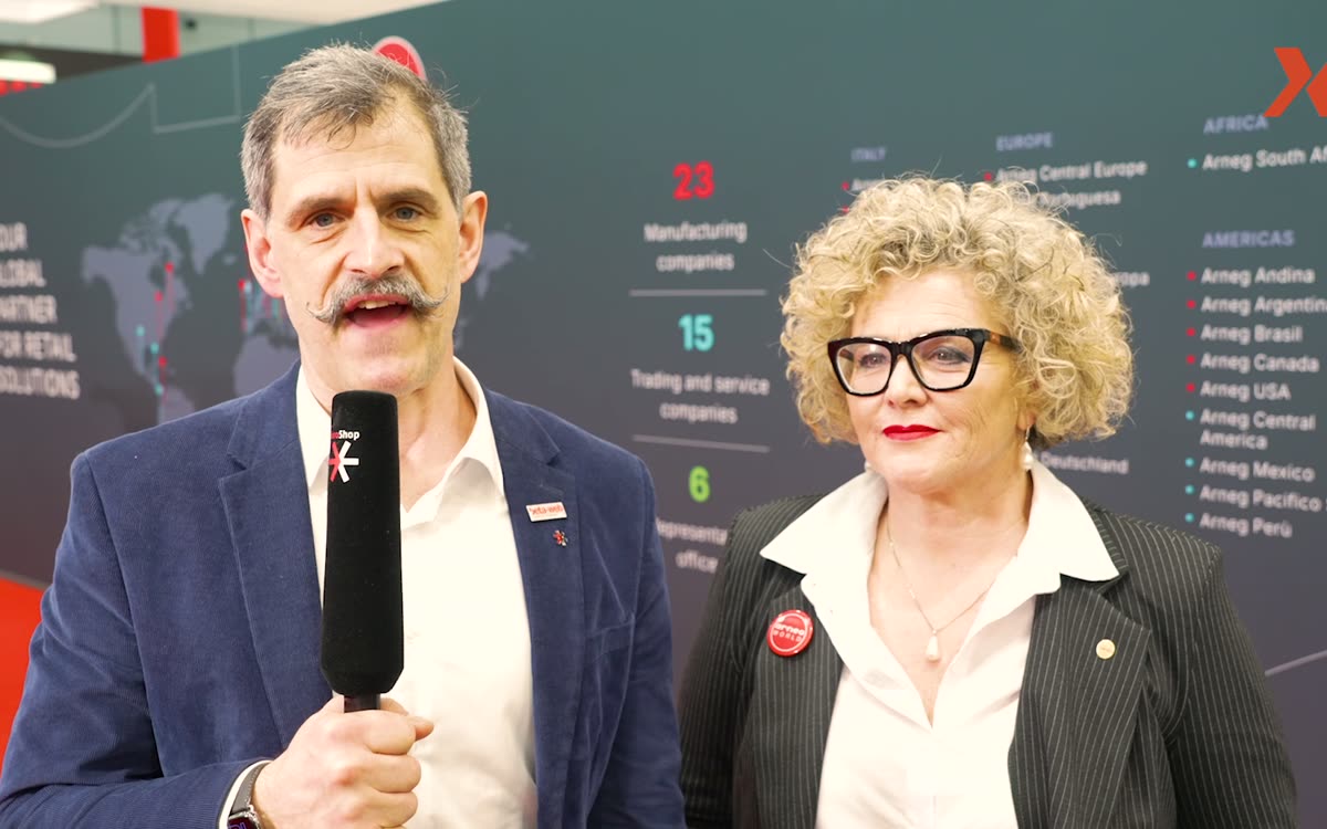 iXtenso-Reporter mit Mikrofon im Interview am Messestand
