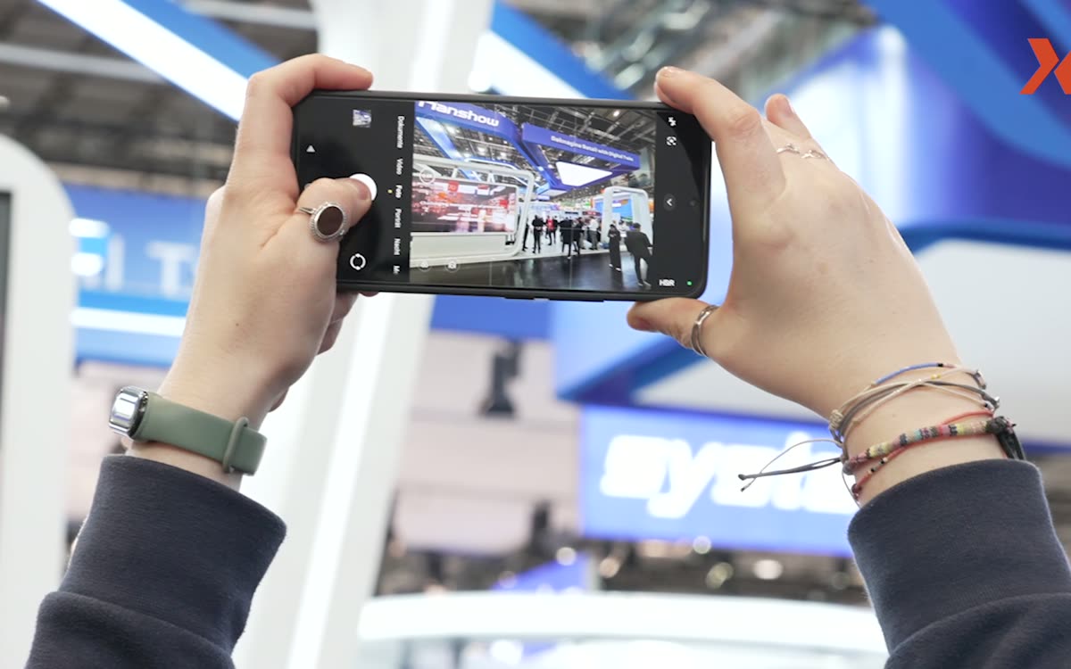 Smartphone filmt eine Messepräsentation